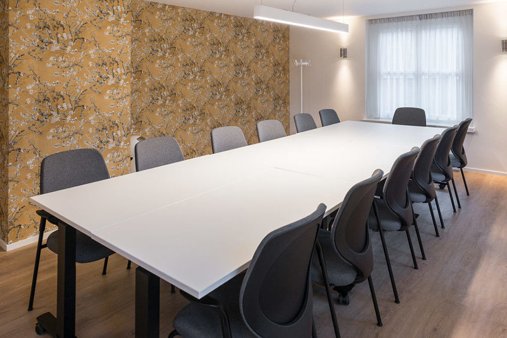 vergaderruimte behang zwart stoelen wit tafel
