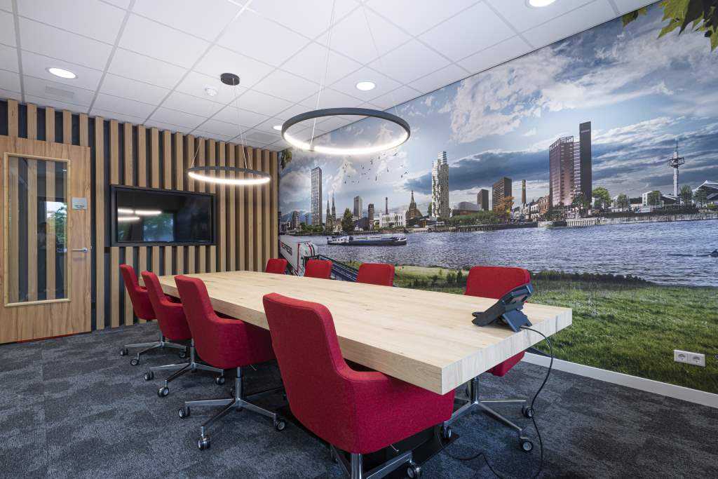 vergaderruimte houten tafel rode stoelen