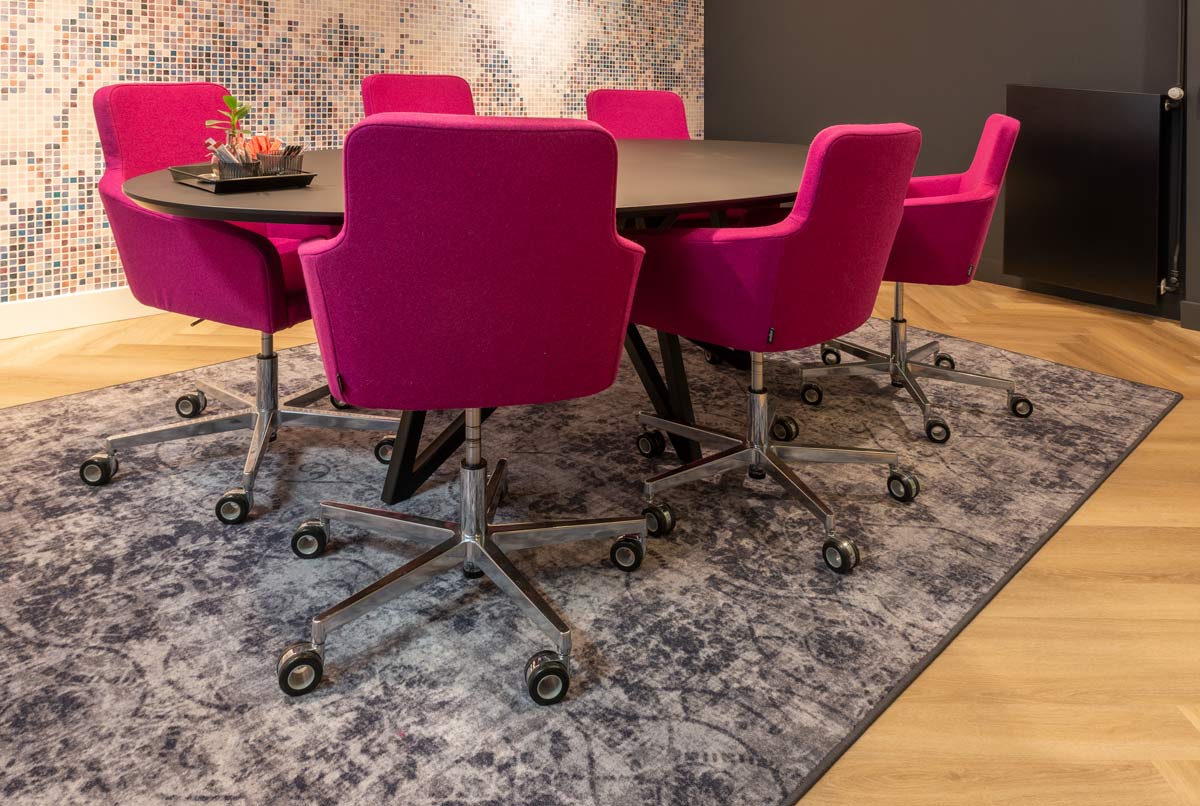 vergadertafel stoelen roze vloerkleed grijs